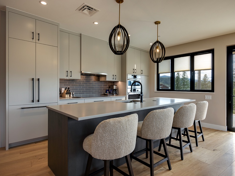 Your modern kitchen awaits, where stylish pendant lighting and sleek countertops set the stage for memorable meals. Gather around the island with mountain views as your backdrop, and let this inviting space become the heart of your stay.