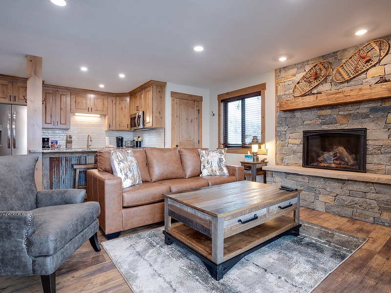 Imagine your evenings here: sink into plush seating by the stone fireplace, with warm wood tones and mountain-inspired decor creating your perfect retreat after a day of adventure.