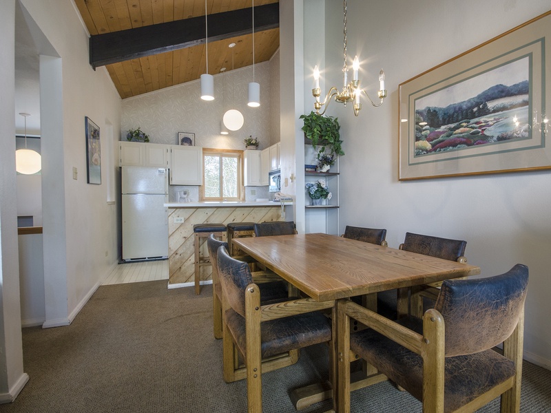 Gather around your private dining table beneath soaring wood ceilings and elegant lighting, with a fully equipped kitchen at your fingertips for memorable meals together.