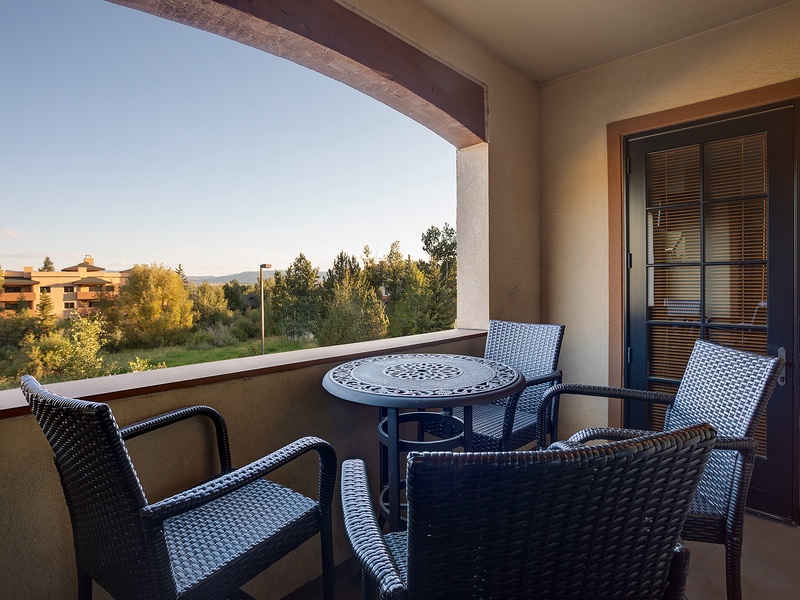 Your private balcony offers a peaceful retreat with comfortable seating, perfect for enjoying morning coffee or evening relaxation while taking in views of the lush surroundings.