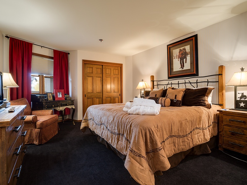 Sink into your king bed with Western charm—plush linens, rustic wood furniture, and warm lighting create your cozy mountain retreat after a day of adventure.