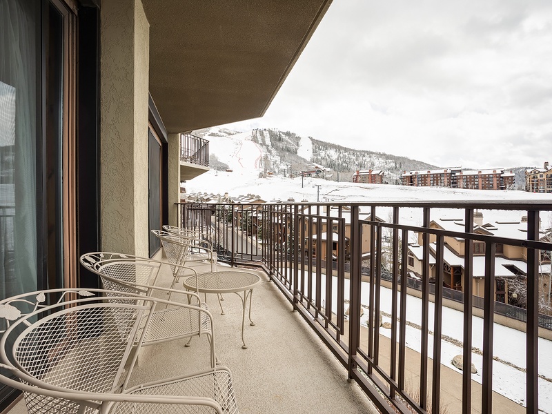 The balcony overlooks snow-covered slopes and mountain views—a perfect spot for your morning coffee or après-ski relaxation with the alpine scenery as your backdrop.