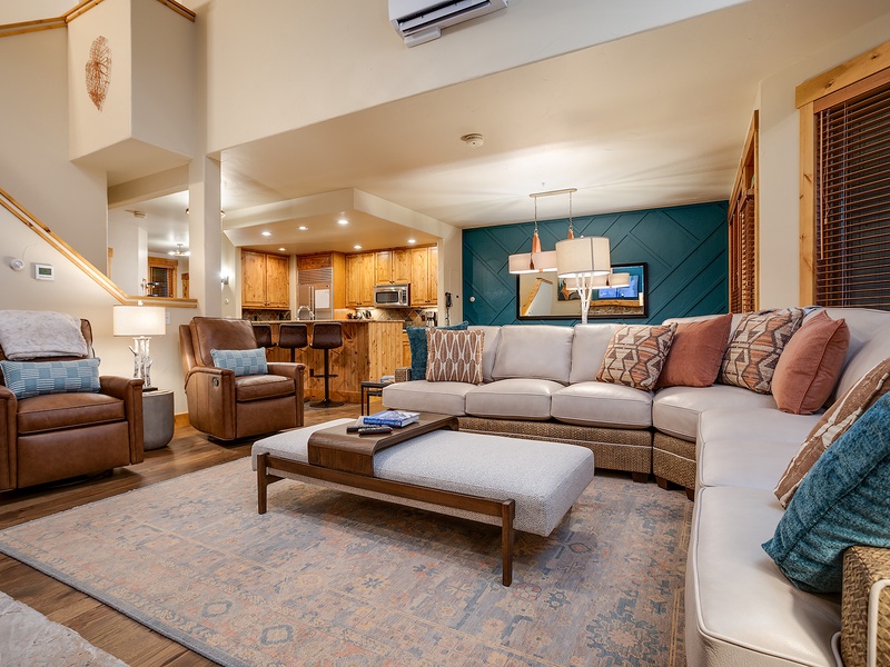 Step into your inviting open-concept living space with vaulted ceilings, plush seating, and warm wood accents creating a cozy mountain retreat atmosphere you'll love coming home to.