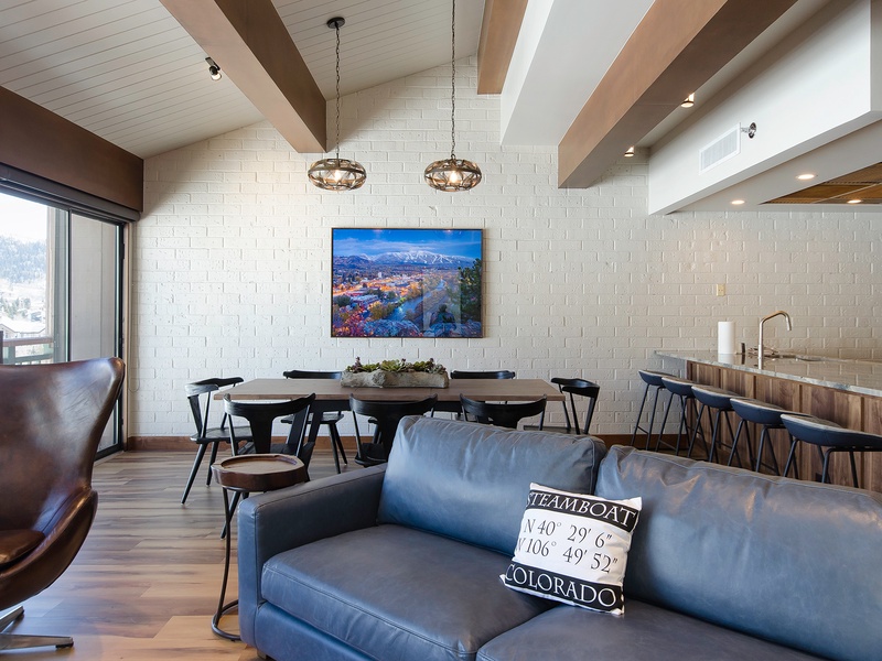 Gather in your open-concept living space featuring exposed beams, modern lighting, and Steamboat coordinates—designed for making memories with family and friends.