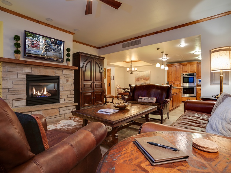 Sink into plush leather seating by the warm stone fireplace, enjoy your favorite shows, and take in the seamless flow into a fully equipped kitchen—your perfect retreat awaits.