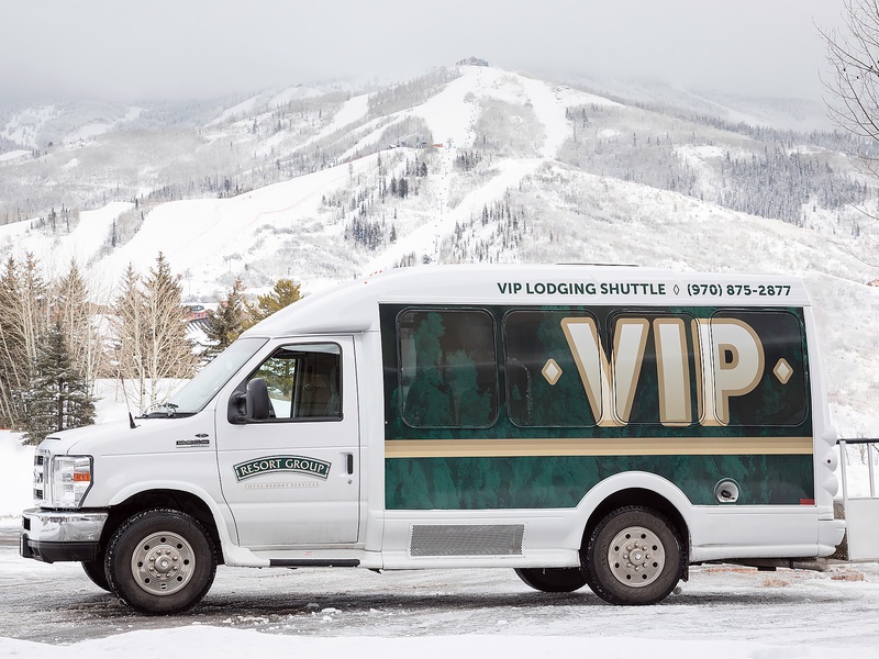 VIP shuttle service stands ready against snow-covered mountain slopes, offering convenient access to winter recreation and nearby ski areas.