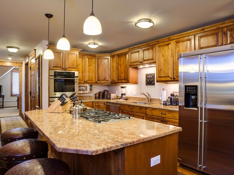 Picture yourself preparing meals in this spacious kitchen, with gleaming granite countertops, rich wood cabinetry, and modern stainless appliances at your fingertips for effortless home-cooked dining.