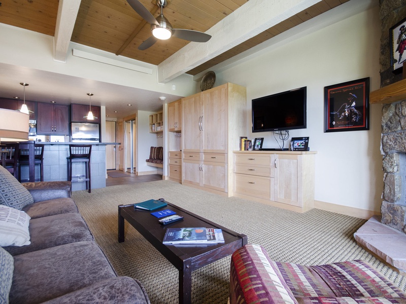 Settle into your spacious living area featuring vaulted wood ceilings, a cozy stone fireplace, and an open layout that flows seamlessly into the modern kitchen—perfect for unwinding after a day of adventure.