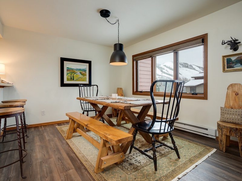 Picture yourself enjoying meals at this rustic dining table, framed by breathtaking mountain views through the window—a perfect blend of cozy charm and natural beauty.