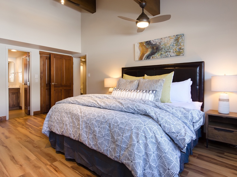 Sink into the plush comfort of this inviting bedroom, styled with crisp linens and warm lighting. The ceiling fan and private bathroom add to your restful retreat.