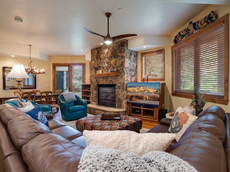 Sink into plush leather sofas by the stone fireplace, where mountain views and warm wood accents create your perfect après-ski retreat.