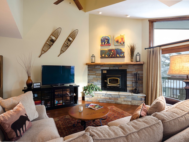 Sink into plush seating by your crackling fireplace, with mountain views framing your cozy retreat. Warm wood accents and thoughtful touches invite you to relax completely.