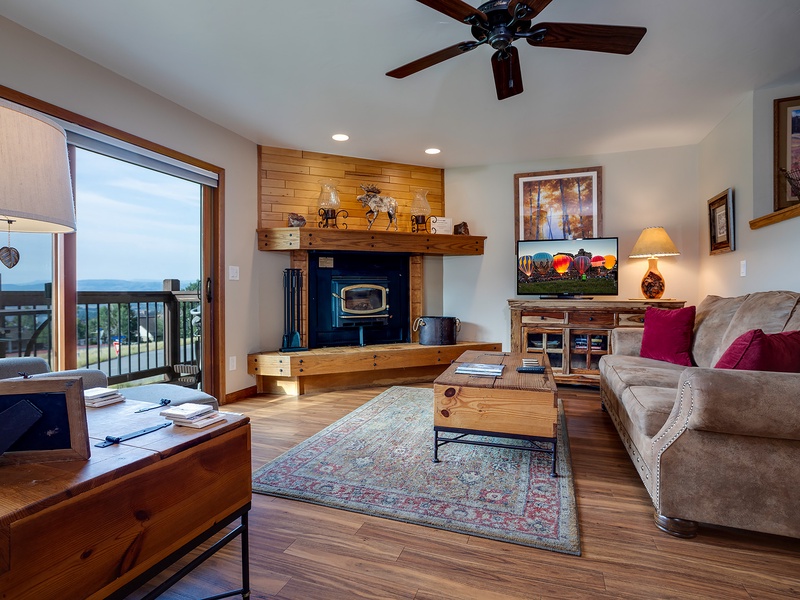 Relax in your spacious living room with a cozy fireplace, comfortable seating, and stunning lake views from your private balcony—perfect for unwinding after a day of adventure.