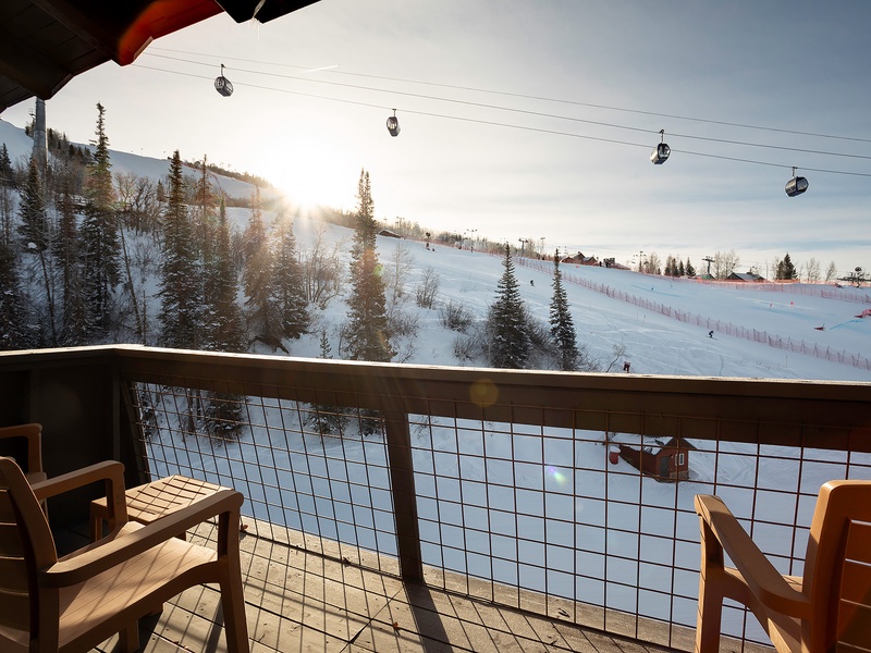 A ski resort at sunrise with snow-covered slopes, pine trees, and ski lifts visible from the property. The area offers direct access to winter sports and mountain recreation.