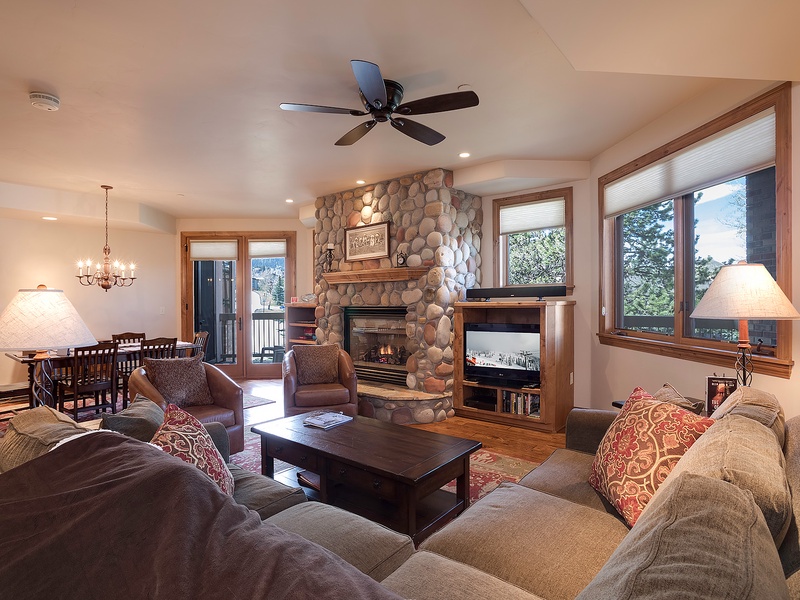 Sink into plush sofas by the stone fireplace as natural light fills your cozy retreat. Perfect for unwinding after a day of mountain adventures, with room to gather and make memories together.