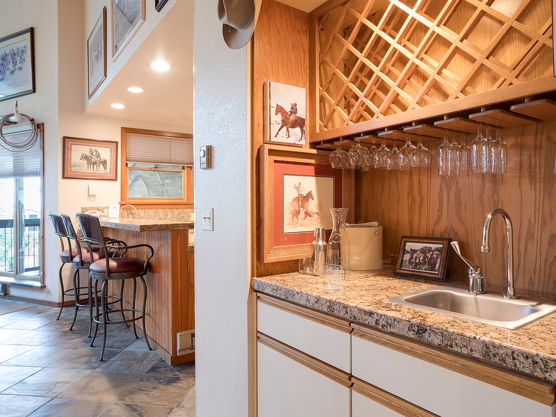 Gather your group at the bar featuring custom wine storage and granite counters, or step through to the breakfast nook framed by western art and natural light streaming in.