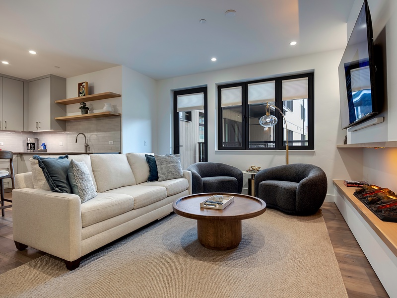 Step into your bright, open-concept retreat where modern design meets mountain comfort. Sink into plush seating by the fireplace, unwind with your favorite show, and enjoy effortless living in this stylish space.