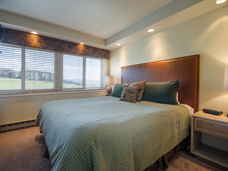 Sink into your plush bed with its designer headboard and crisp linens. Large windows frame scenic views, while soft lighting and tasteful decor create a restful retreat.