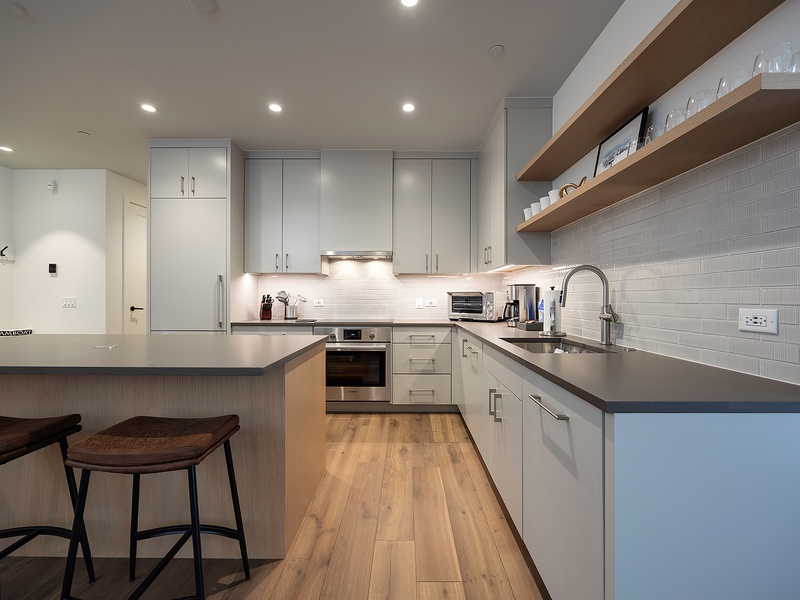 Step into your sleek, fully-equipped kitchen with modern appliances and stylish finishes. Open shelving and a breakfast bar invite you to whip up meals or sip morning coffee in comfort.