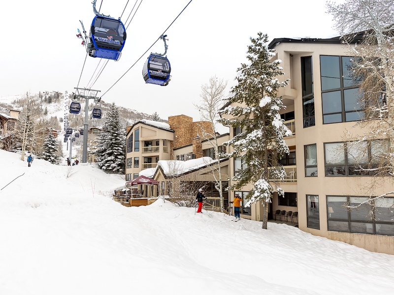 A premier ski resort village with gondola access steps from the property, surrounded by snow-covered slopes and mountain vistas.