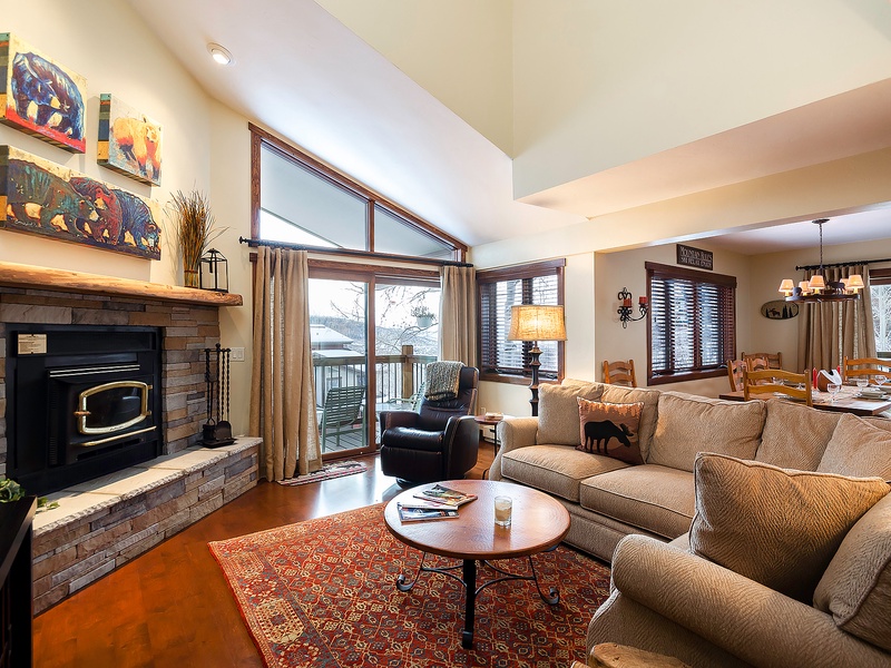 Sink into plush sofas by the cozy fireplace, where vaulted ceilings and abundant natural light create your perfect mountain retreat for relaxing evenings.