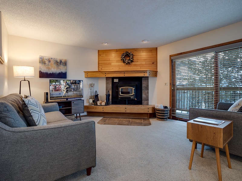 Sink into plush sofas by your private fireplace and enjoy streaming your favorites on the TV. Natural light pours through expansive windows overlooking the trees, creating your perfect retreat.