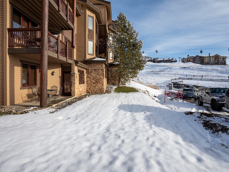 Alpine property located steps from ski slopes, with mountain gondola access and parking. Surrounded by winter scenery and neighboring lodges, offering an ideal ski vacation location.