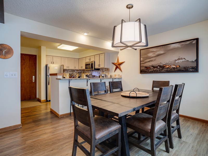 Gather around this spacious dining table for meals and memories, with a fully equipped kitchen just steps away for your culinary adventures.