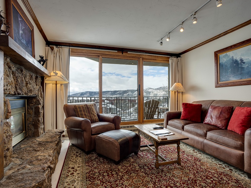 Unwind in your inviting living space, where a cozy stone fireplace and plush leather seating create the perfect retreat. Step out to your private balcony and take in stunning mountain views.