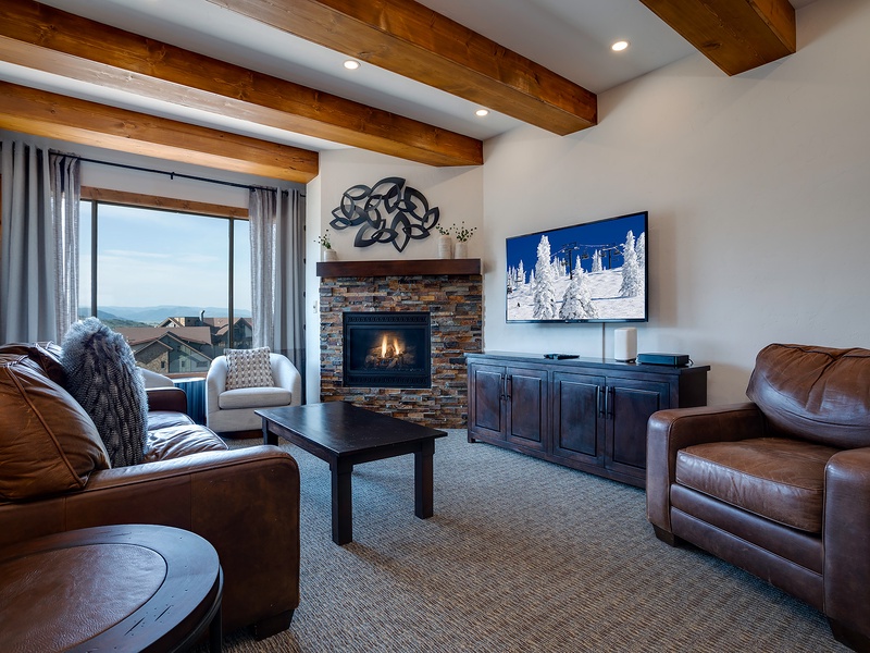 Unwind in your inviting living room where mountain views and a warm fireplace create the perfect retreat. The rustic beamed ceiling and plush seating invite you to relax after a day of adventure.