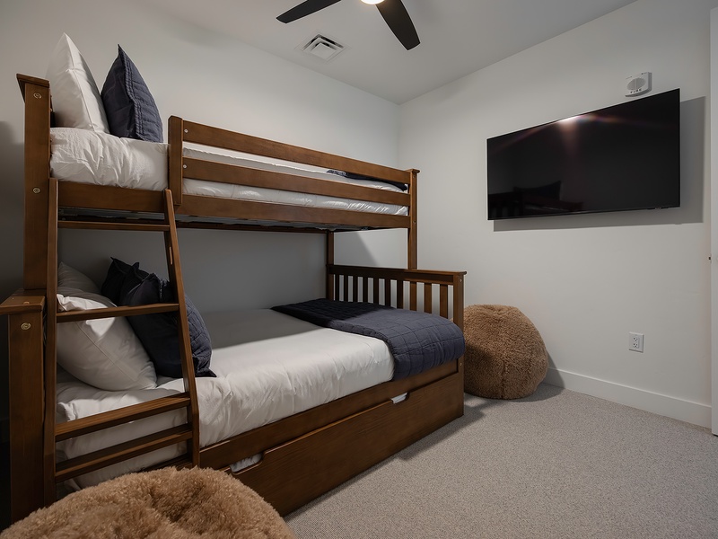 Your kids will love this cozy bunk room, complete with soft linens, plush seating, and a wall-mounted TV for movie nights after a day of adventure.