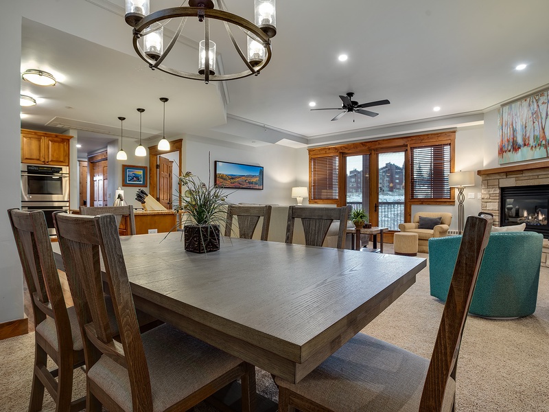 Gather around this spacious dining table for memorable meals, with a cozy fireplace and mountain views creating the perfect backdrop for your getaway.