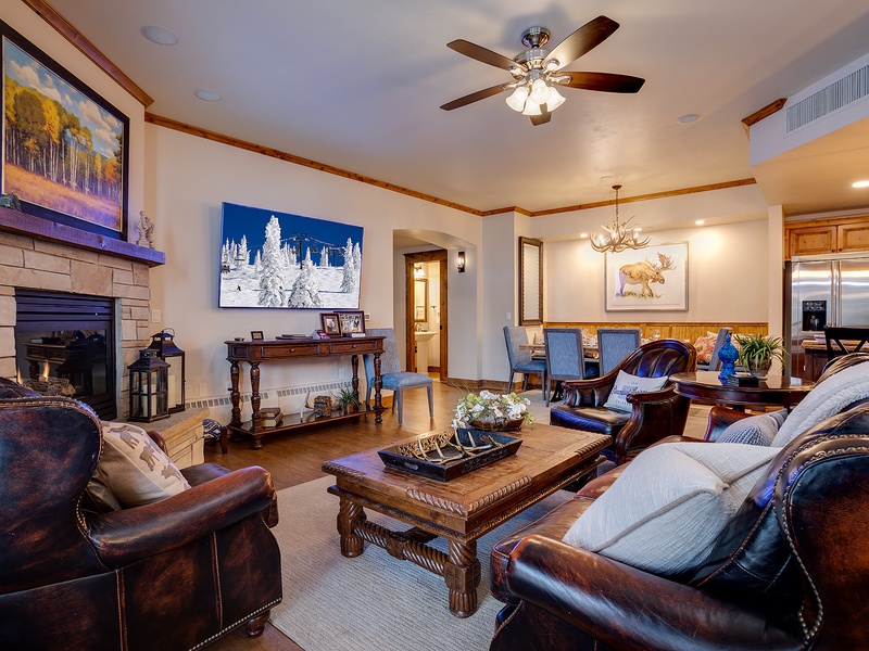 Sink into plush leather sofas by the stone fireplace, where rustic charm meets mountain elegance. Warm wood tones and art-filled walls create your perfect retreat.