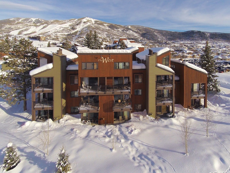 A winter wonderland awaits at The West Condominiums, nestled in a pristine mountain valley with snow-covered peaks rising all around. This property features cozy balconies and sits near ski slopes.