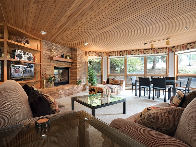 Cozy living space with plush seating, a warm fireplace, and sunlit windows overlooking the peaceful outdoors—your perfect retreat for relaxing evenings and family gatherings.