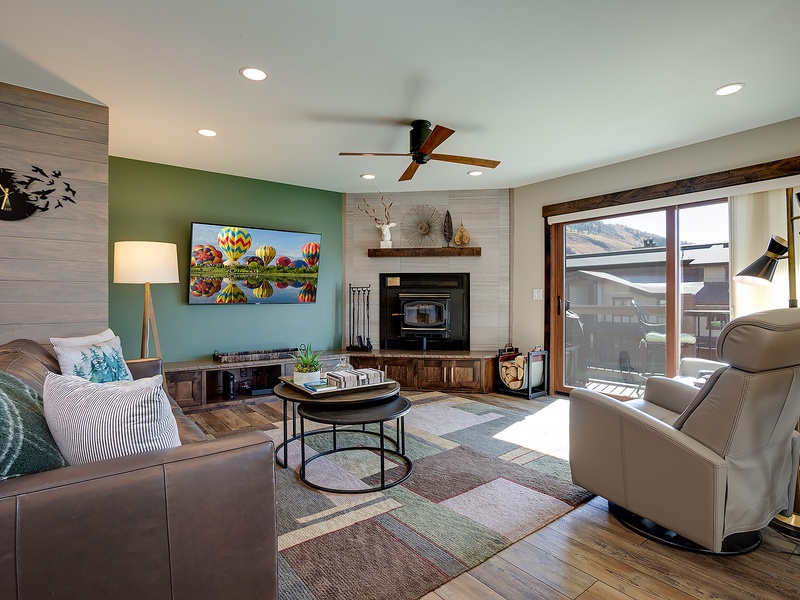 Settle into your cozy living room where natural light streams through the balcony doors, a warm fireplace awaits, and your favorite shows come alive on the flat-screen TV.
