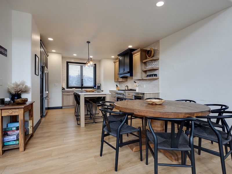 Your open-concept kitchen and dining area invites you to gather around the rustic wood table, cook meals in the modern kitchen, and feel right at home in this warm, thoughtfully designed space.