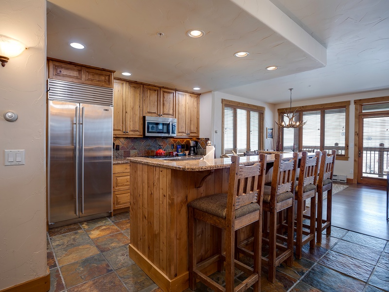 Gather around the breakfast bar in your fully-equipped kitchen, where rustic wood and granite invite you to start each morning with mountain views through large windows.