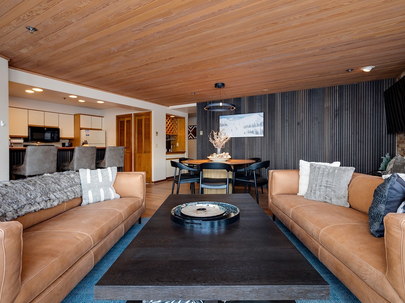 Relax into buttery leather sofas beneath warm wood ceilings, your perfect retreat for cozy evenings after mountain adventures or lakeside explorations.