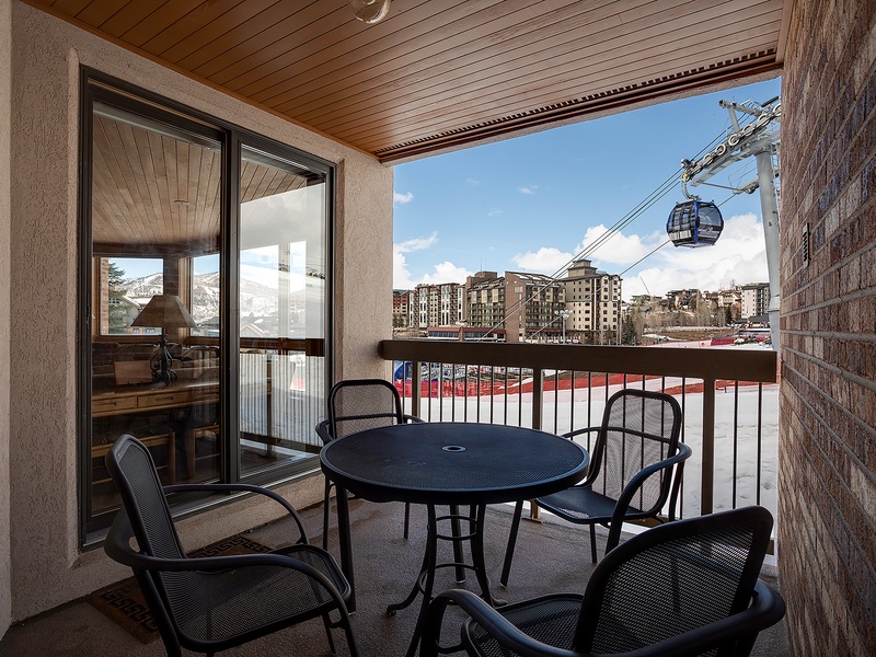 Your private balcony offers mountain views and gondola access, perfect for morning coffee or après-ski relaxation with seating for four.
