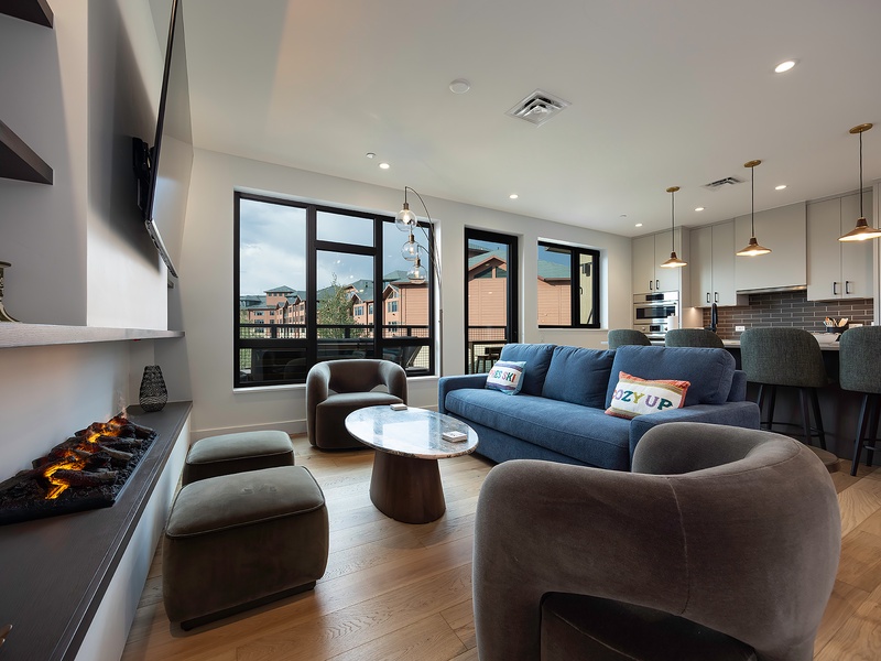 Unwind in this sleek living space, where modern comfort meets style. Plush seating, warm ambient lighting, and an open layout invite you to relax, while the connected kitchen makes entertaining effortless.
