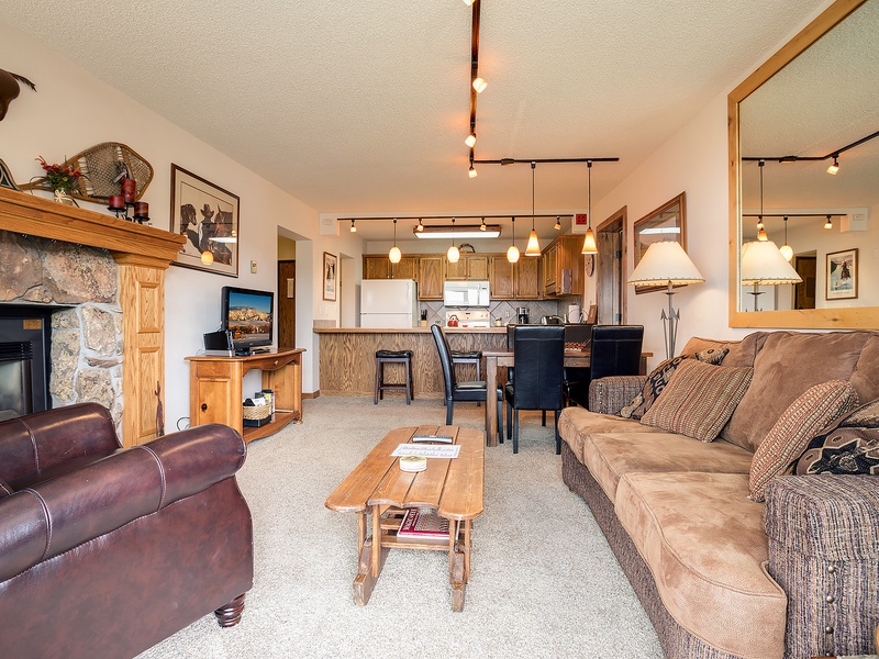 Unwind in your cozy open-concept space where rustic charm meets comfort—plush seating, a warm fireplace, and a fully-equipped kitchen invite you to relax and feel right at home.
