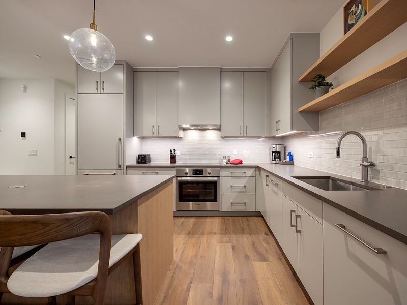 Your fully equipped kitchen invites you to prepare meals with ease, featuring sleek countertops, modern appliances, and warm wood accents that create a welcoming space for cooking and gathering.