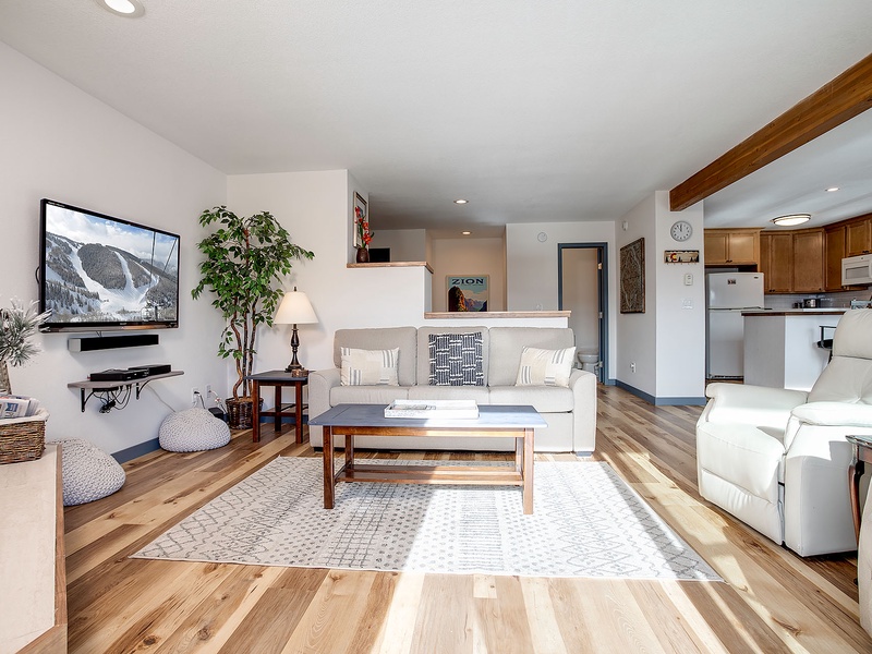 Unwind in your bright, open living space with comfortable seating, a cozy area rug, and a well-appointed kitchen just steps away—perfect for relaxing after a day of adventure.