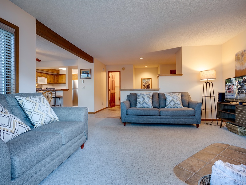 Step into your spacious living room with comfortable seating and an open layout that flows into the kitchen—perfect for relaxing after a day of adventure.