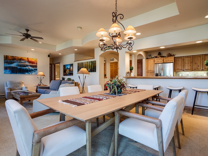 Gather around this inviting dining table where your group can share meals and memories. The open layout flows seamlessly into a cozy living space and fully-equipped kitchen, making your stay feel like home.