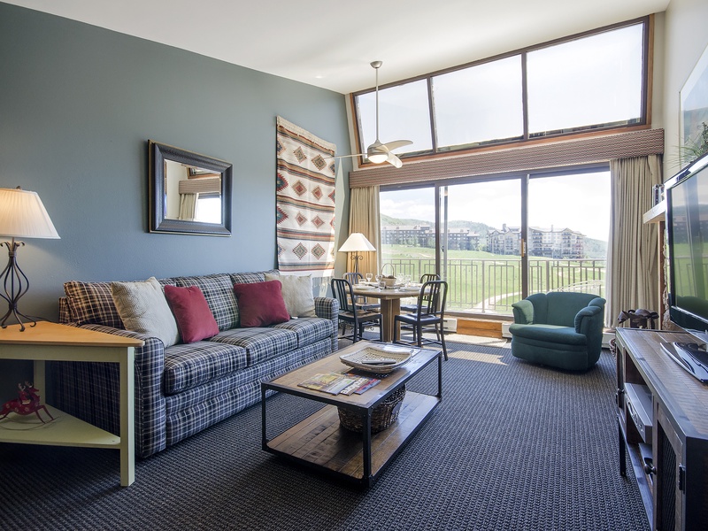Settle into your cozy living room and enjoy expansive golf course views through floor-to-ceiling windows, perfect for unwinding after a day of mountain adventures.