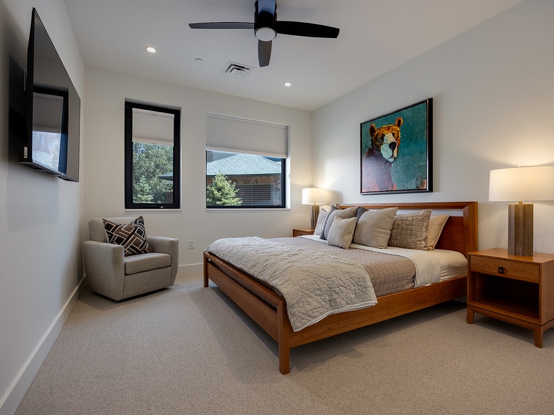 Slip into your serene bedroom, where a plush bed and soft lighting invite you to unwind. Natural light streams through modern windows, while a ceiling fan keeps your space perfectly comfortable.