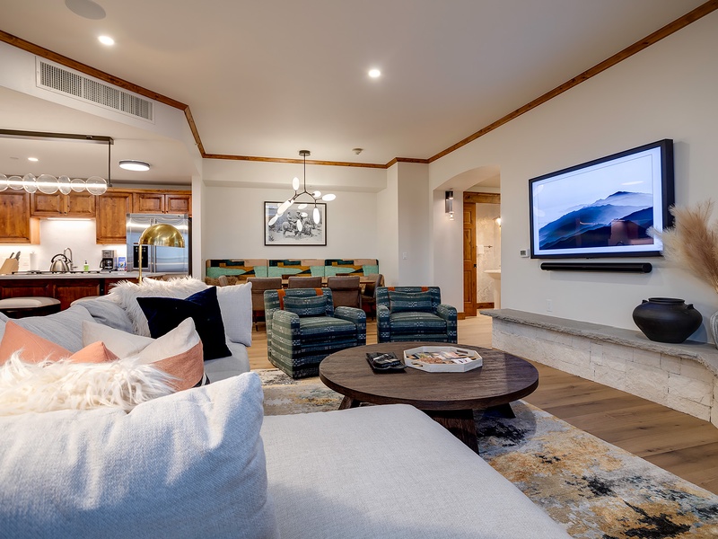 Sink into plush seating and unwind in your open-concept living space, where modern comfort meets mountain elegance with a cozy fireplace and entertainment center.