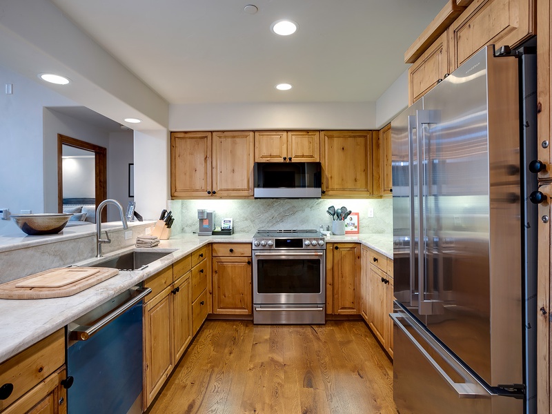 Your fully equipped kitchen features warm wood cabinetry, sleek stainless appliances, and plenty of counter space for preparing home-cooked meals during your stay.